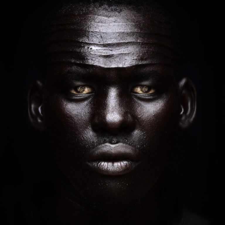 A man with black skin and yellow eyes.