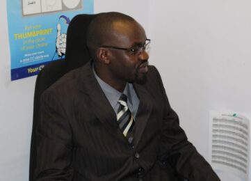 A man in suit and tie sitting on top of a chair.