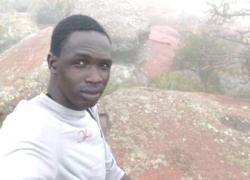 A man is taking a selfie on top of a mountain.